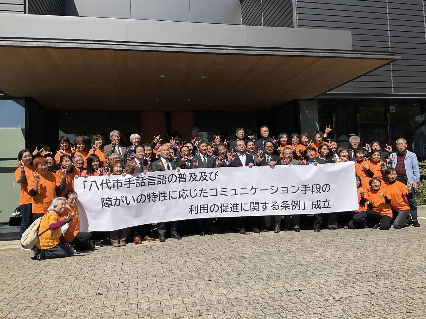 「八代市手話言語の普及及び障がいの特性に応じたコミュニケーション手段の利用の促進に関する条例」成立おめでとうございます（写真は喜びを分かち合う関係者の皆さん）
