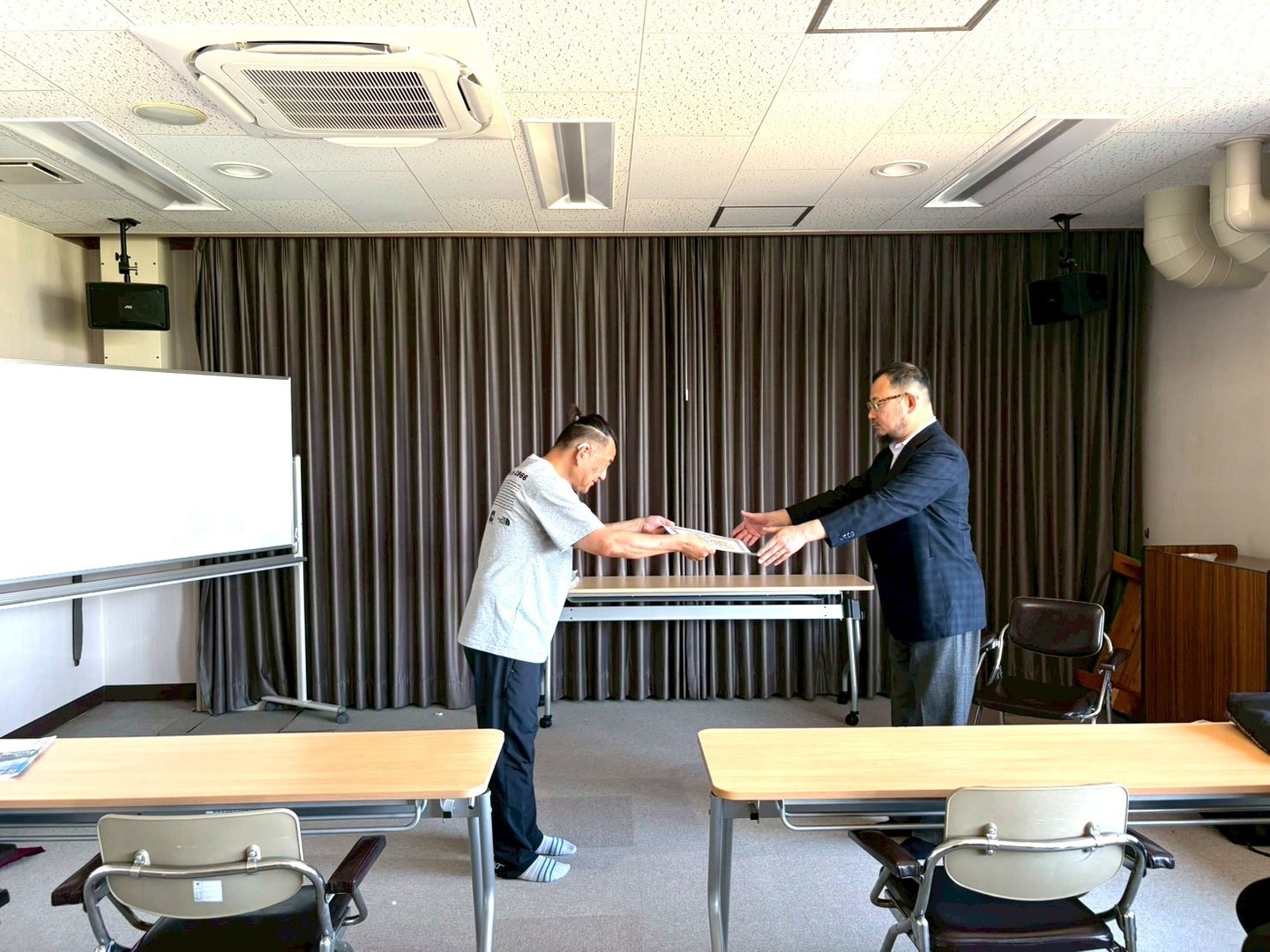 ソフトバレーボール部から3位入賞の報告（左:寺尾賢二郎氏、右:東禎事務局長）